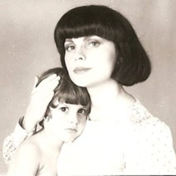 A sepia-toned portrait of a woman with a bob haircut embracing a young child.