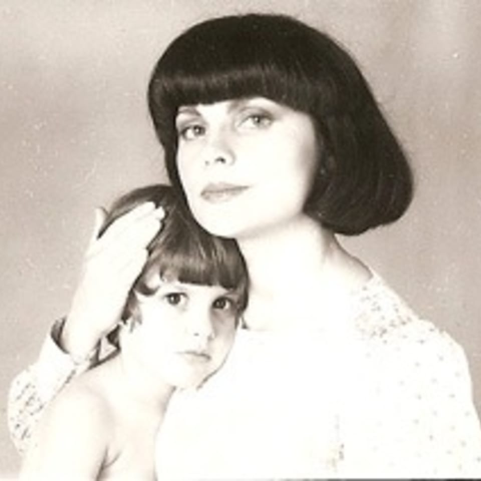 A sepia-toned portrait of a woman with a bob haircut embracing a young child.