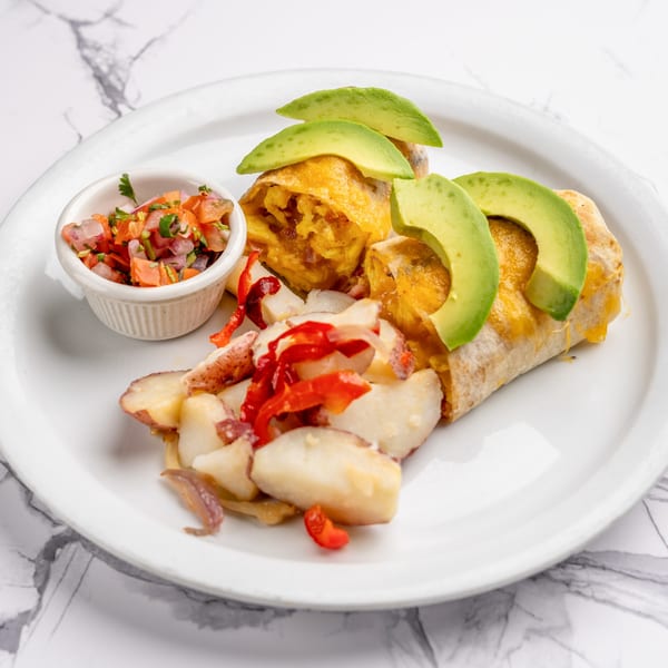 Breakfast burrito with avocado slices, a side of roasted potatoes, and a small bowl of salsa.