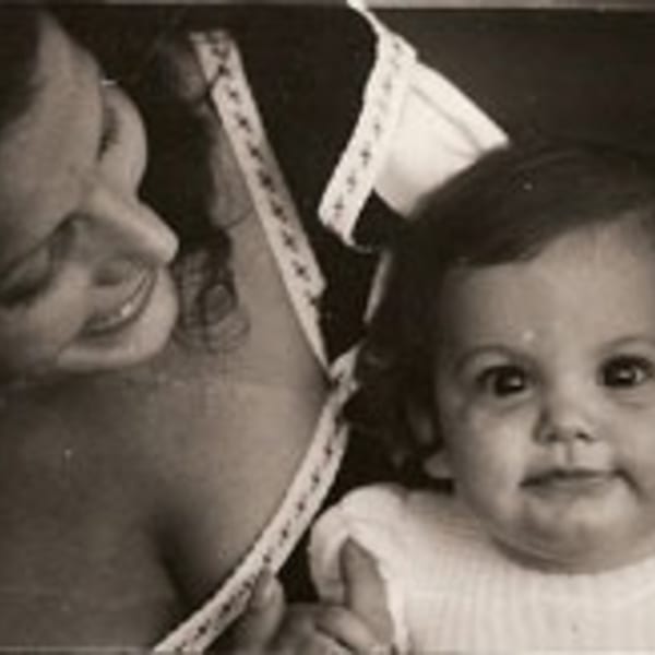 A vintage black and white photo of a smiling woman holding a baby.