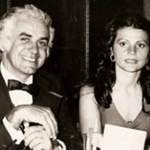 A smiling man in a tuxedo and a woman in a dress at The Bistro K.