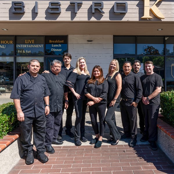 The Bistro K staff, dressed in black, stand united outside the Italian restaurant.